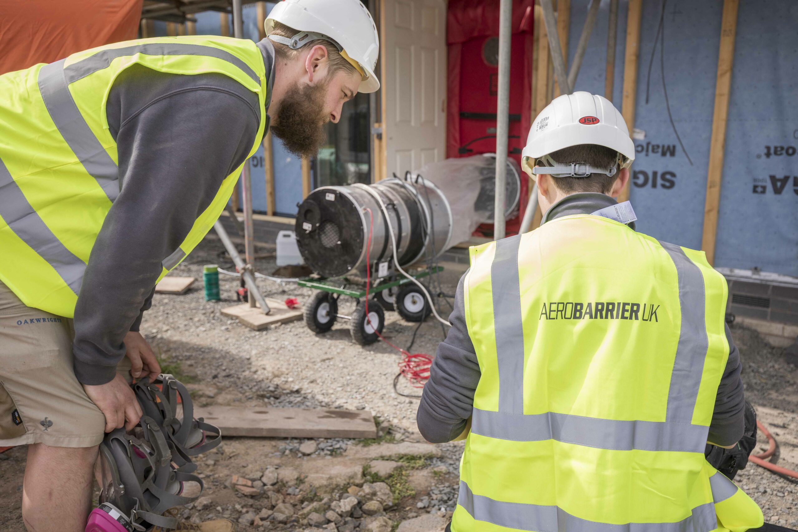 AeroBarrierUk team performing an airtest and seal on an oak framed building. Two team members are looking at the computer as the seal takes place